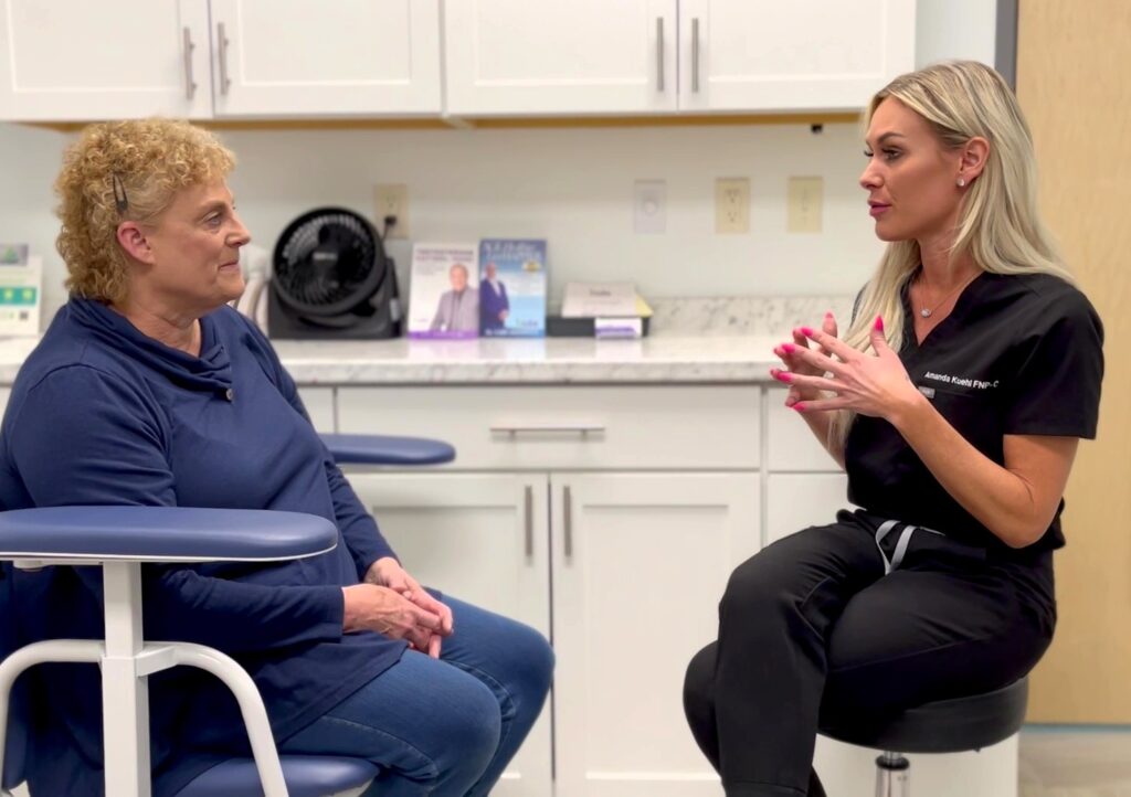 Provider and patient sitting in a treatment room discussing the weight loss program offered at Iowa Wellness Center. The provider is explaining how they combine nutritional recommendations with weight loss medications like semaglutide near Cedar Rapids.
