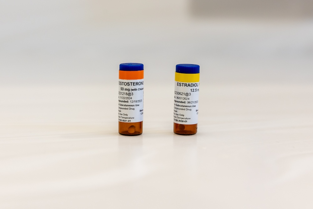 Two bottles of testosterone and estrogen sitting on a counter in preparation for hormone replacement therapy near Cedar Rapids.